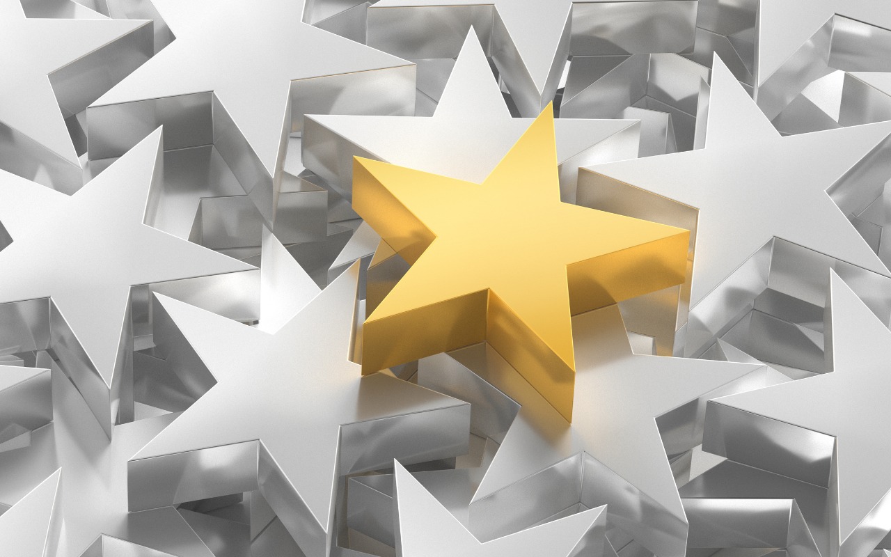 Gold star standing out above other stars in silver/monochrome color, signifying standout performance.