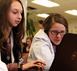 Two female students working on laptop