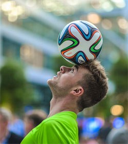 Man balancing futbol soccer ball on head