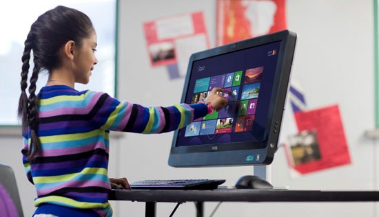 A young girl touches the screen of an OptiPlex All-In-One