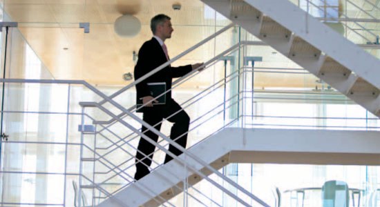 photo of man climbing stairs of a factory to illustrate Dell Services and SAP webinar on smart factory