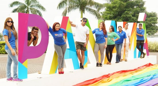 Dell employees in Panama pose by colorful letters during Pride month activities