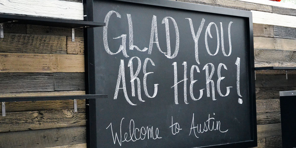Chalk board with Glad You Are Here! Welcome to Austin! written on it