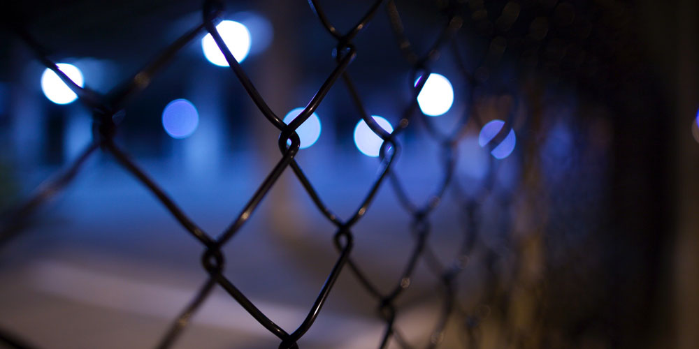 blue lights seen through a security fence