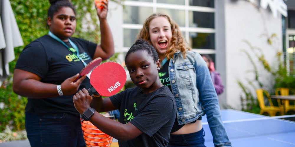 Three girls at DWEN Summit 2017 goofing around and playing ping pong