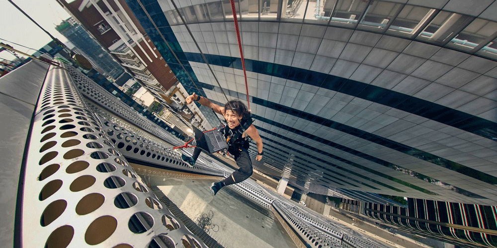 photographer benjamin von wong hangs off the side of a building with his dell latitude rugged laptop