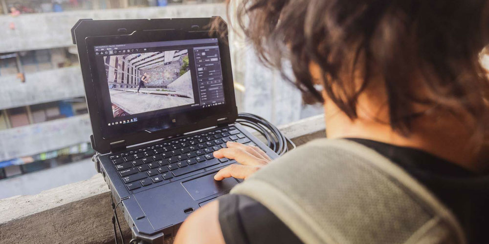 photographer ben von wong looks at digital images on his dell latitude rugged laptop