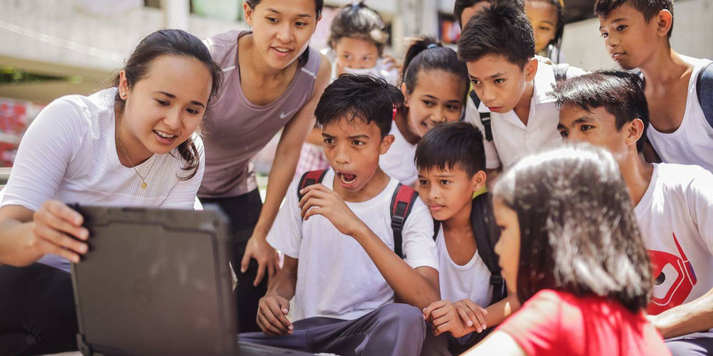 school children in manila look at ben von wong photos on his dell latitude rugged laptop