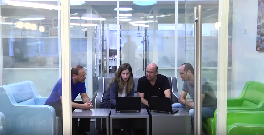 group of four Dell EMC employees sitting together discussing a project