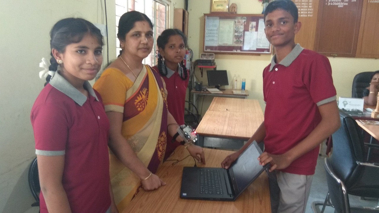 students and their teacher with a dell laptop