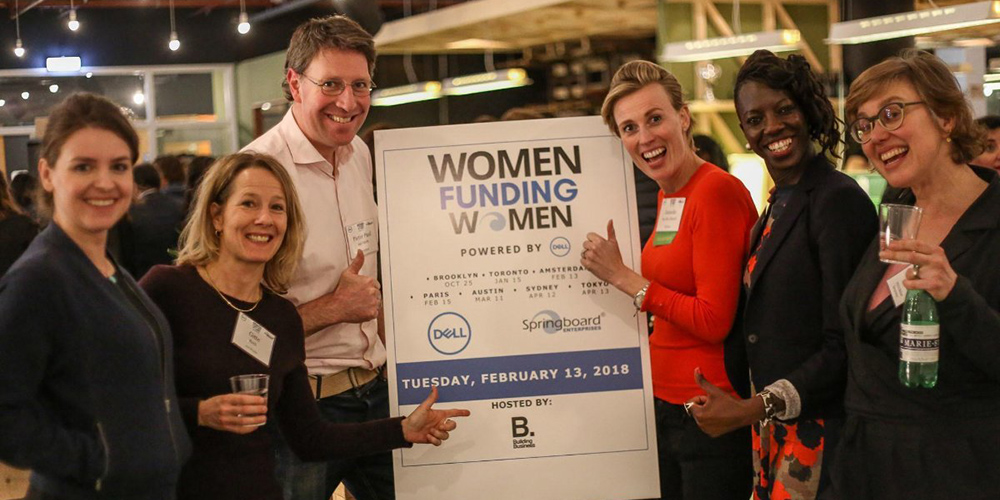 group of people standing by sign at women funding women event