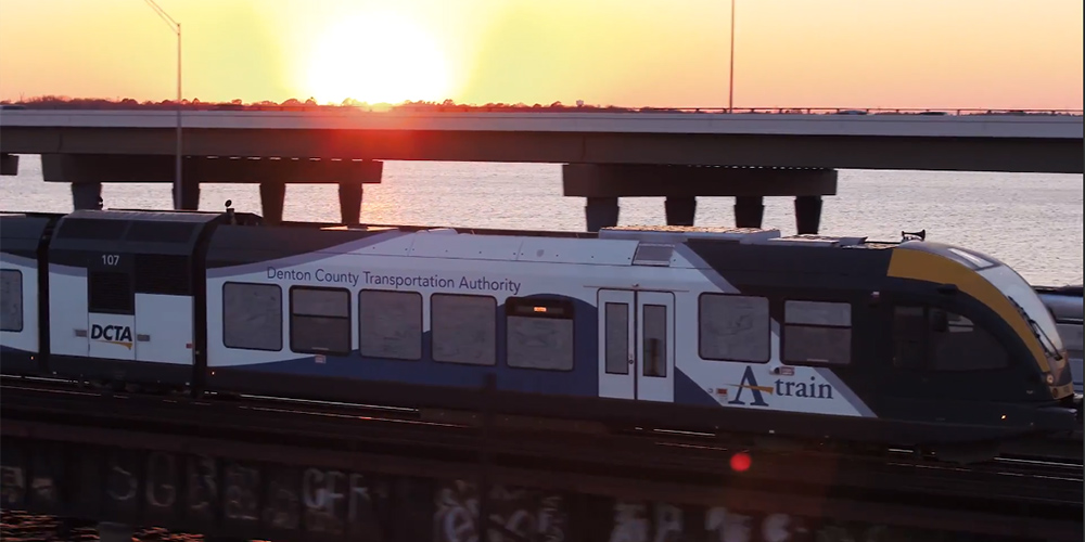 commuter train on bridge at sunset