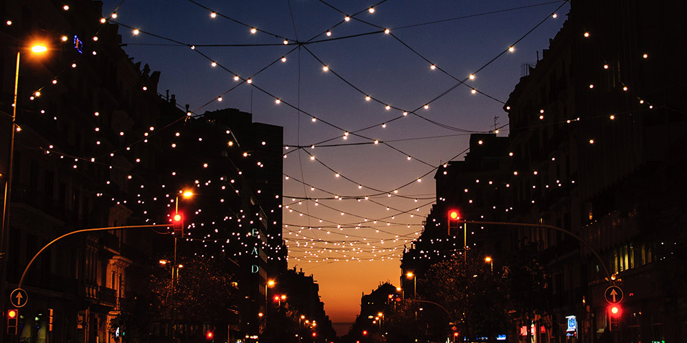 string lights criss-cross a city street at night