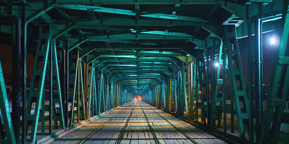 photo looking across a bridge at night Photo by Karol Smoczynski on Unsplash
