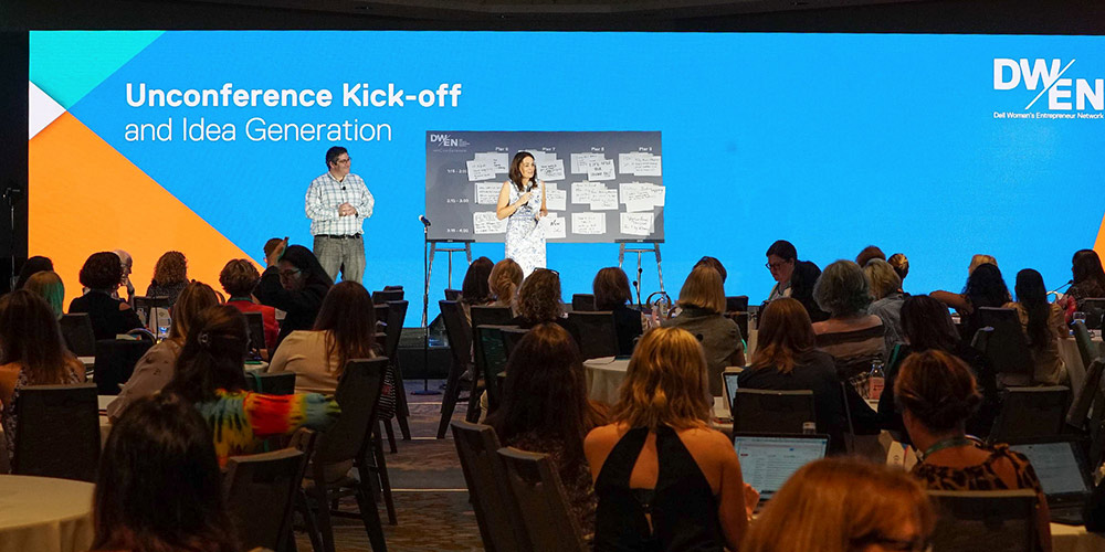 photo of two people on stage in front of unconference participants at DWEN Summit 2018