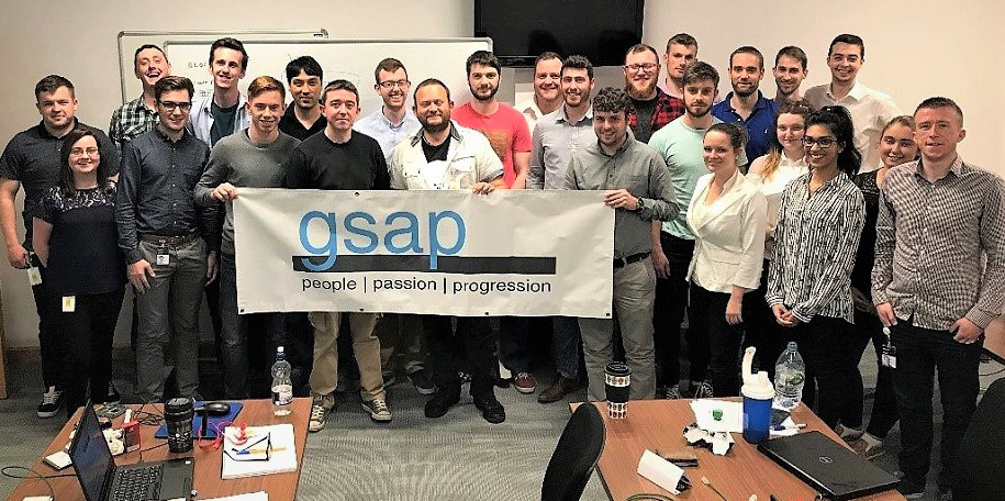 group of people holding a sign that says gsap which stands for the Dell Global Services Associate Program