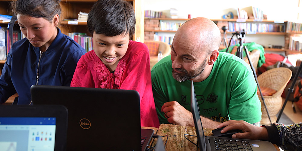 Darrel Ward of Dell works with children at Jhamtse Gatsal on Dell laptops