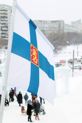 Flag of Finland on wind at winter cloudy day