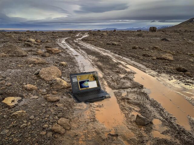 Dell Latitude 5430 Rugged on the ground in muddy water of off-road tire tracks. 