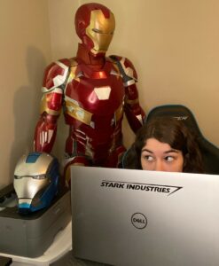Emily Yarid, aka Emily the Engineer with her Dell Precision 5750 mobile workstation, 3D printer, and Iron Man suit and helmet in the background. 