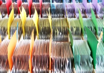 Paper files separated by colorful folders.