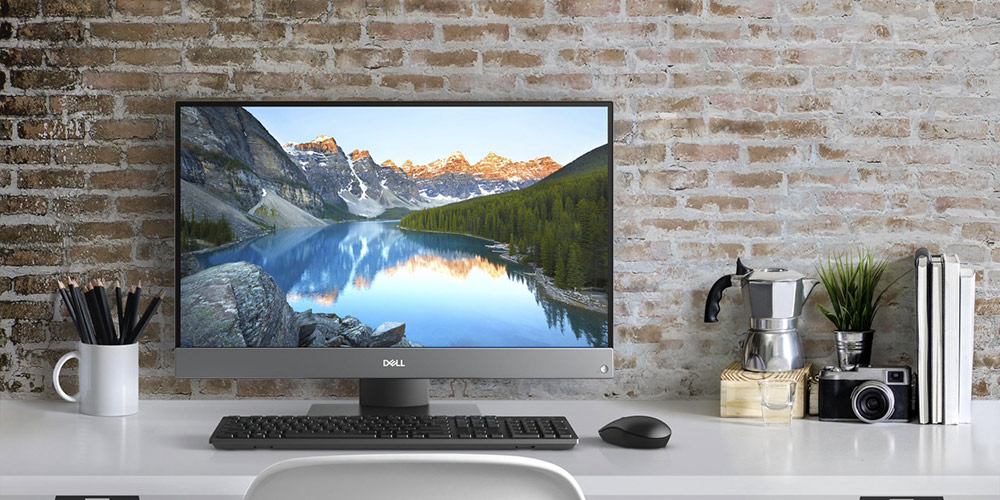 Dell Inspiron all-in-one AIO desktop computer on white desk in front of brick wall