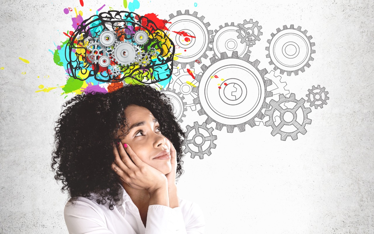 Young African-American woman looking throughtful while brainstorming. Image of gears and mind at work behind her.