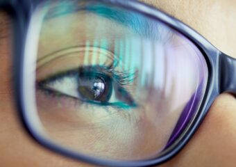 Closeup image of woman's eye wearing glasses, looking forward.