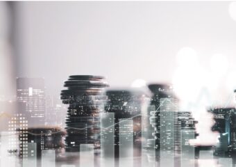 Digital image of stacked money with city skyline superimposed.