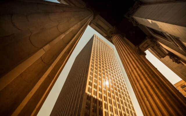 View looking up between two columns at a high rise building.