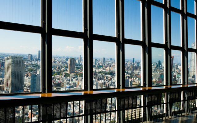 Looking out a row of windows across a city skyline.