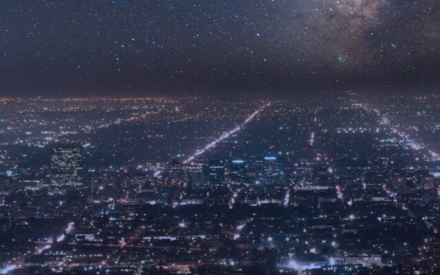 Aerial view of a cityscape at night with stars in the background.