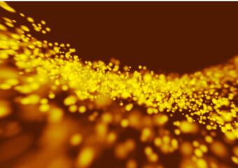 Abstract image of gold light particles in motion.