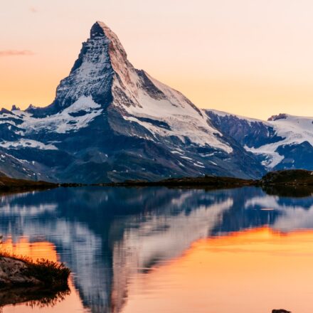 The Matterhorn mountain in the Swiss Alps, with reflection on a nearby lake.
