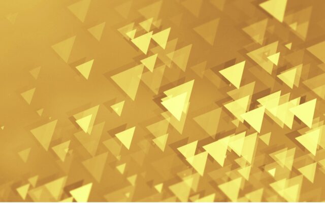 Abstract image of yellow triangles against a gold background, appearing to be moving toward top right corner.