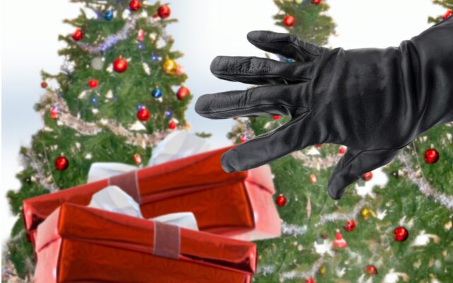 Gloved hand reaching for holiday gifts, with decorated Christmas trees in the background.