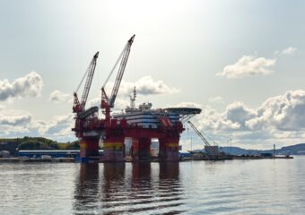 Oil drilling platform in the Norwegian Sea with a partly sunny sky in the background.
