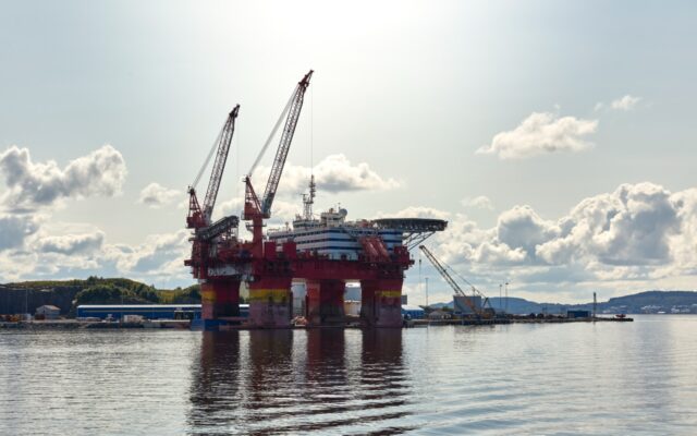 Oil drilling platform in the Norwegian Sea with a partly sunny sky in the background.