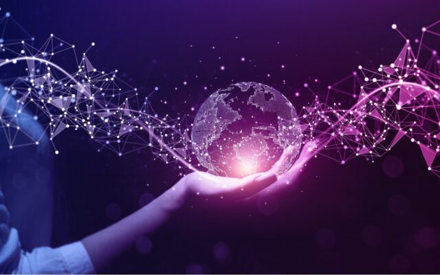 Digital image of a globe made of information code with new data moving through it, held by a woman's hand, against a purple background.