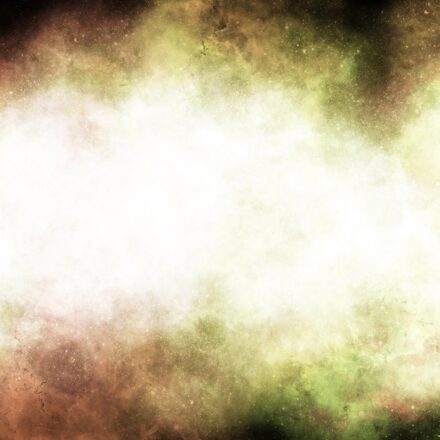 Abstract image of cloud of light colored gasses and matter in space against a starry background.