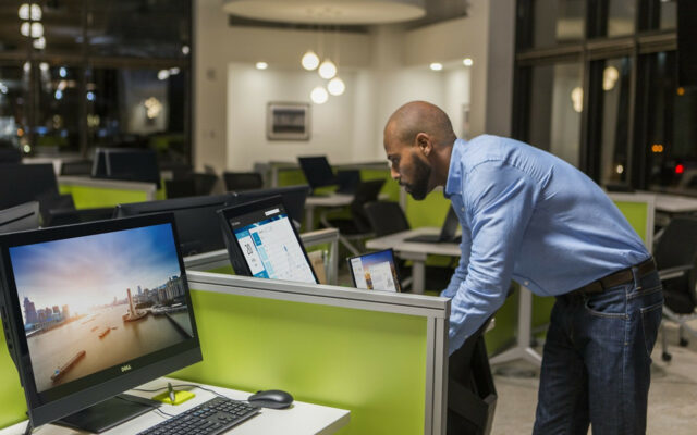 African-American male IT pro installs Dell ProDeployPlus on Dell systems in an office setting after hours.