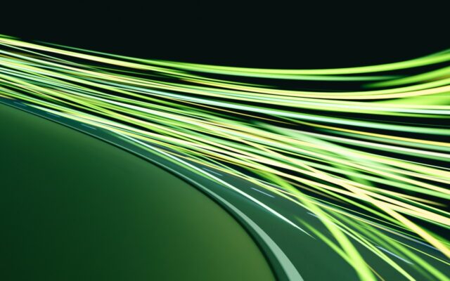 Rays of green light in high speed motion against a black background.