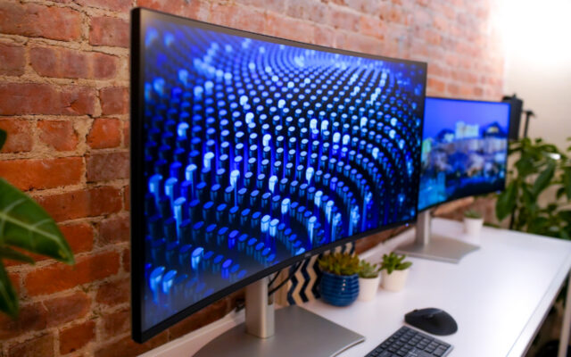 Dell UltraSharp 40 monitor on desk in front of a brick wall.